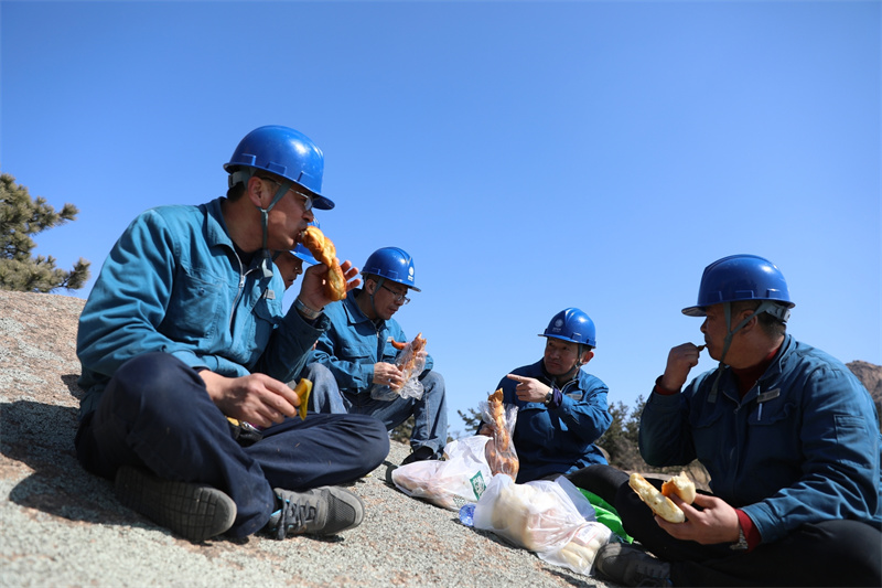3月16日，山東榮成市供電公司員工對槎山上的電力線路進行特巡。線路巡檢了一半時正值中午，巡檢人員在山上用餐。.jpg