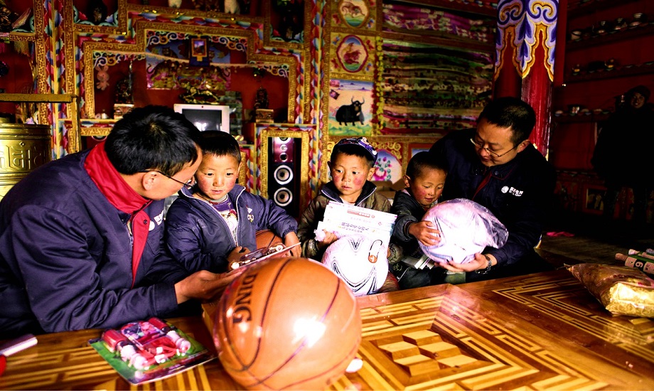 在藏区，汪志刚(左一)被孩子们亲切地称为“汪阿爸”。田海摄
